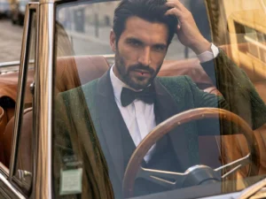 Traje de novio Magnus, pose frontal coche detalle smoking slim fit con tonalidades verdes y doradas, Atelier Masculini