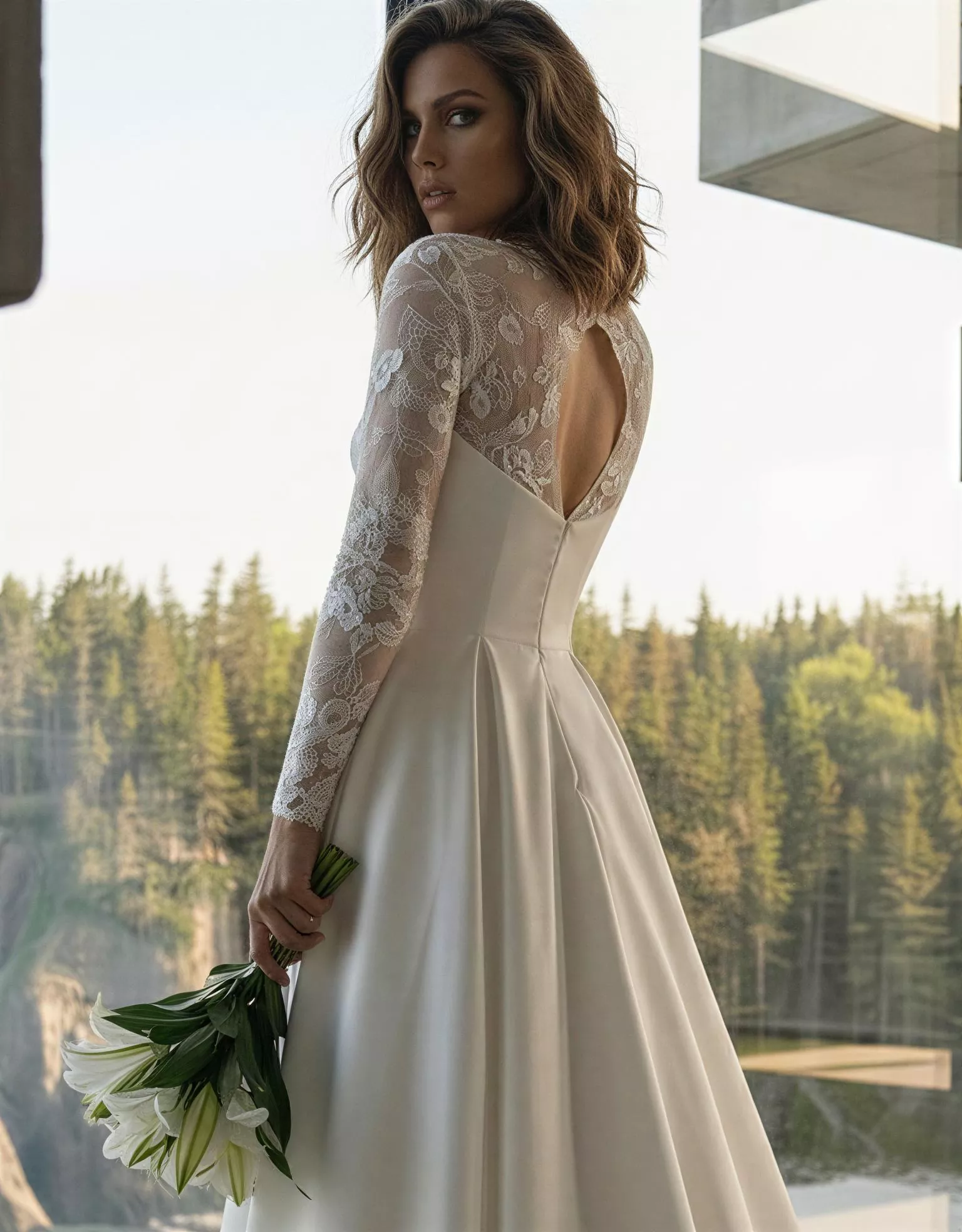 Vestido de Novia Jupiter pose espalda detalle escote V picos encaje espalda semidescubierta corte A Atelier Boheme