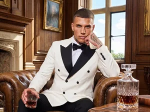 Traje de novio Olivano, pose sentado, color blanco marfil , esmoquin de ceremonia cruzado, Atelier Masculini