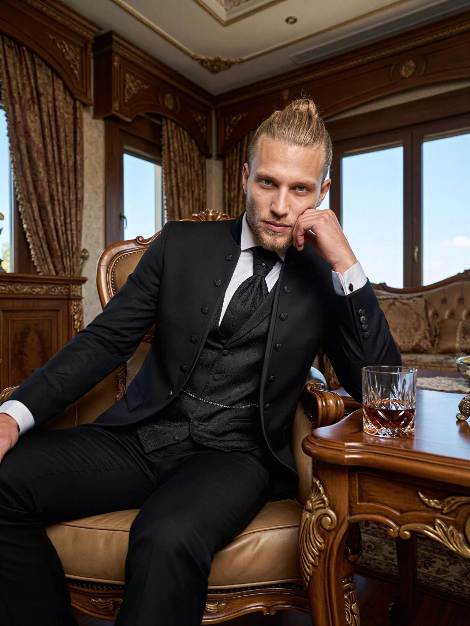 Traje de novio Ra, pose sentado, color negro, cuello mao con doble botonera de ceremonia, Atelier Masculini