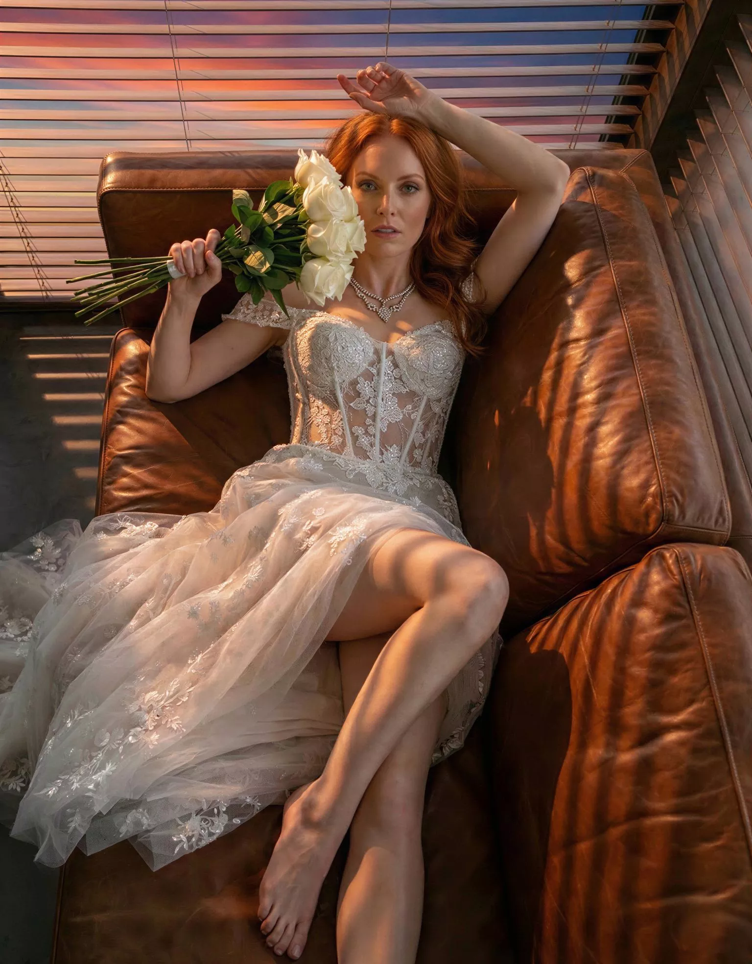 Vestido de novia Jubilee, pose sofá, corte A, escote corazon, espalda recta, tul con torso de encaje Atelier Boheme